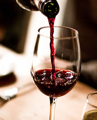 pouring red wine into a wine glass